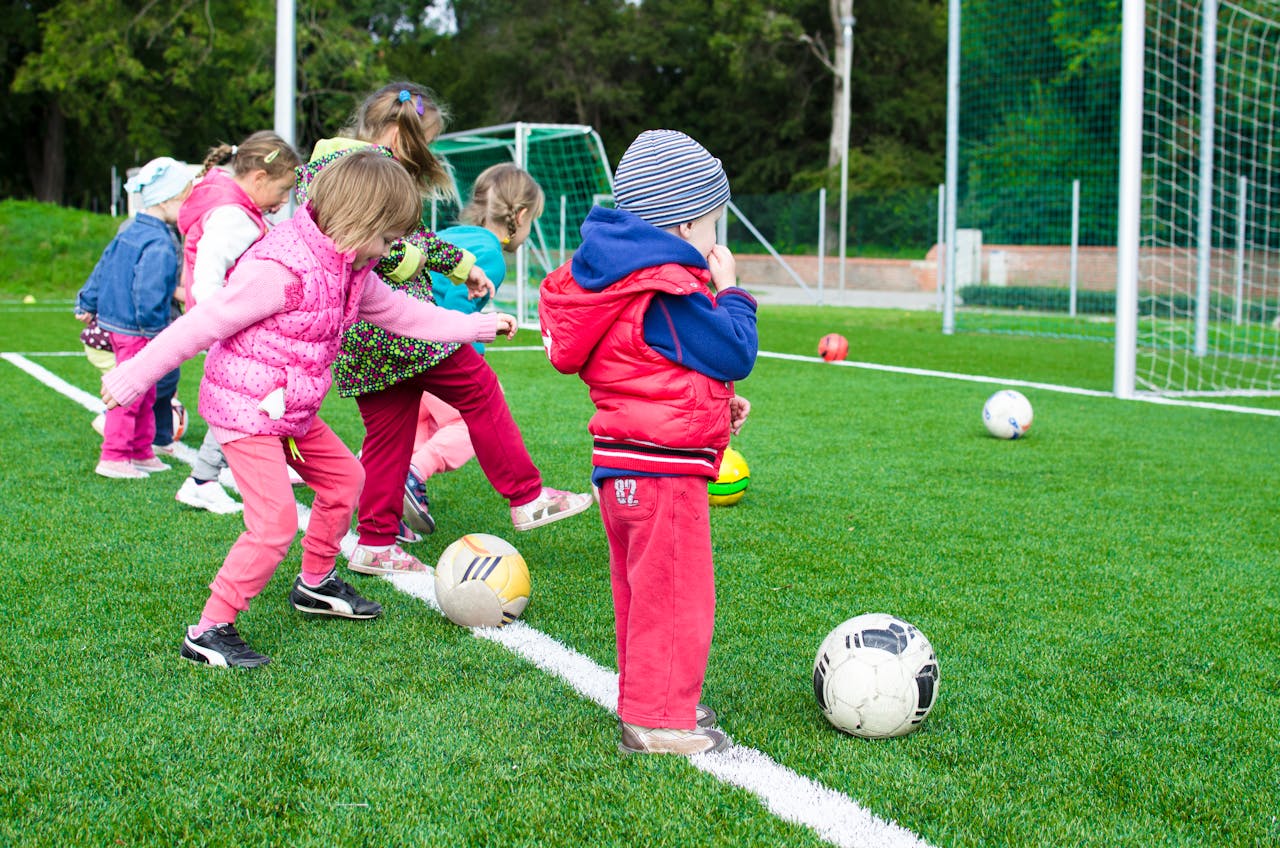 Young children playing football on a field